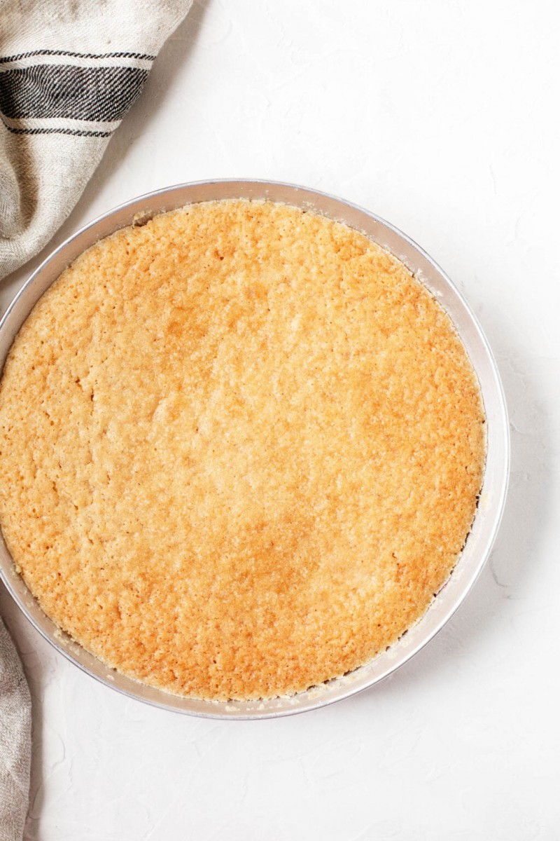 A pie plate that's been baked with a vegan vanilla cake.