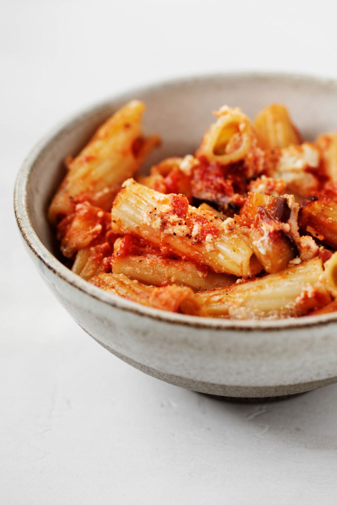 Close up of vegan baked rigatoni, with cashew tofu ricotta and juicy tomatoes.