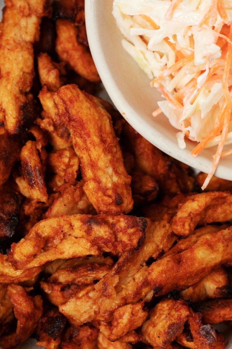 A zoomed in image of soy curls that are coated in BBQ sauce.