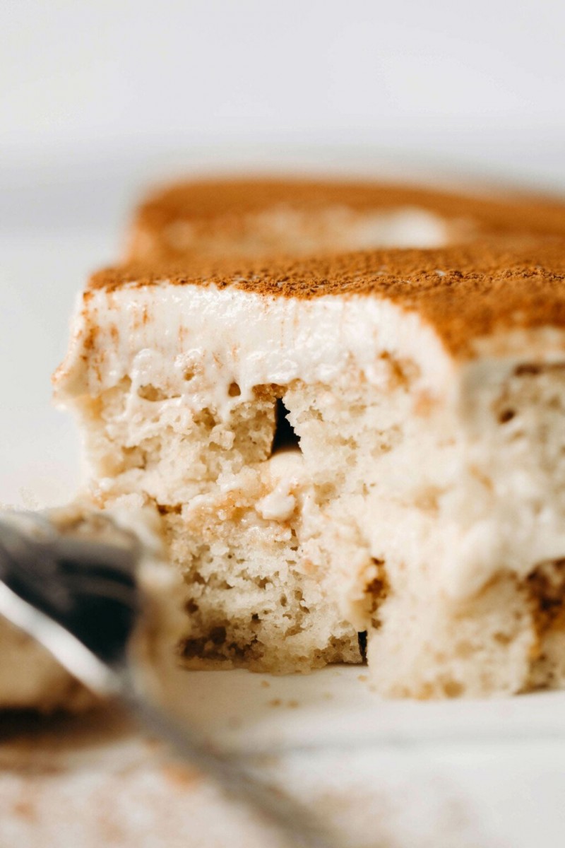 A close up image of a fluffy, creamy cross section slice of tiramisu.